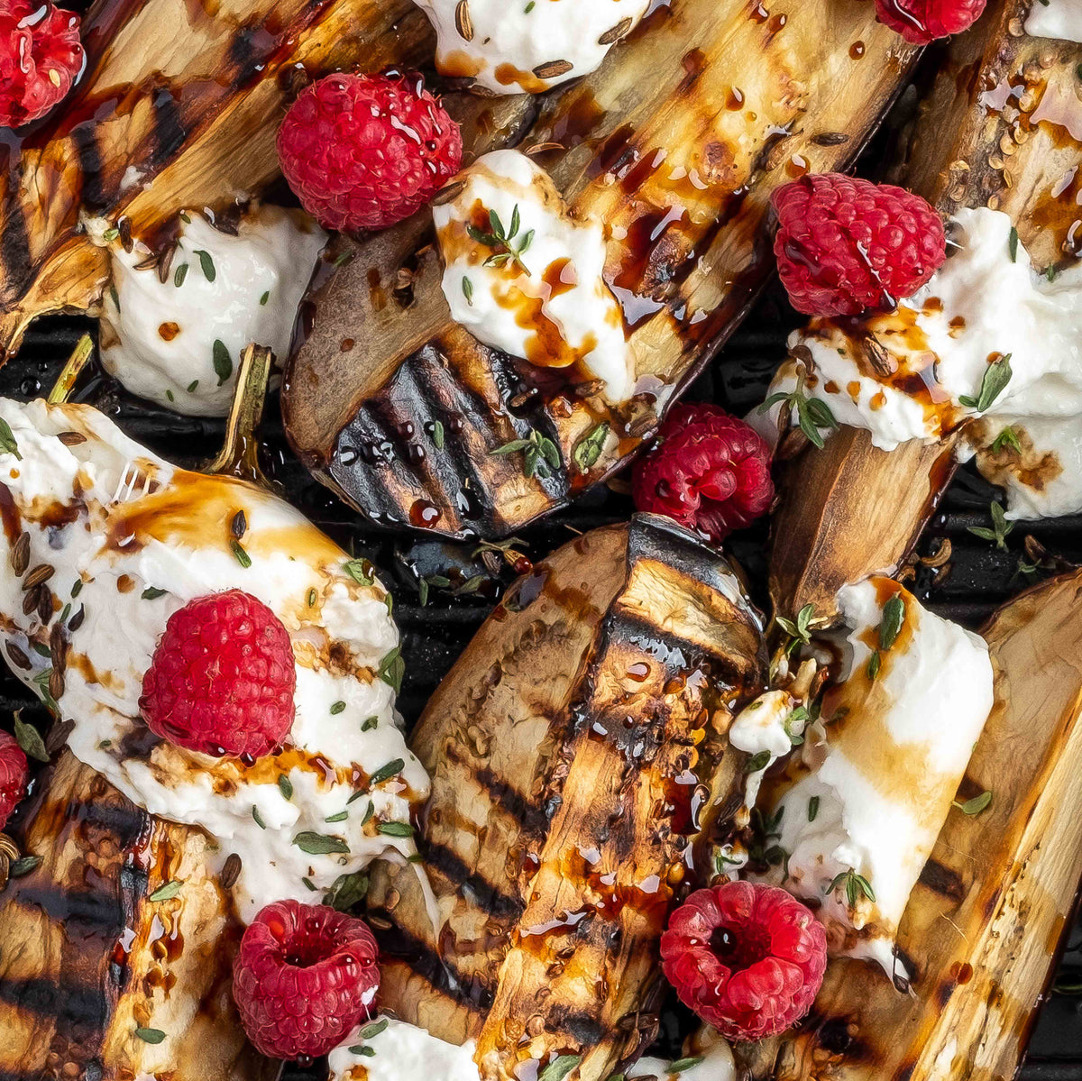 Gegrillte Auberginenspalten mit Burrata und Himbeeren bedeckt